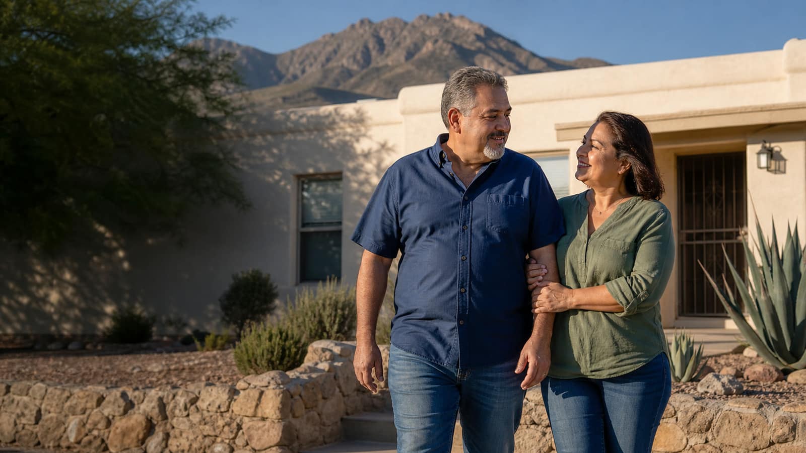 An El Paso couple walking forward from their stucco home with relieved smiles