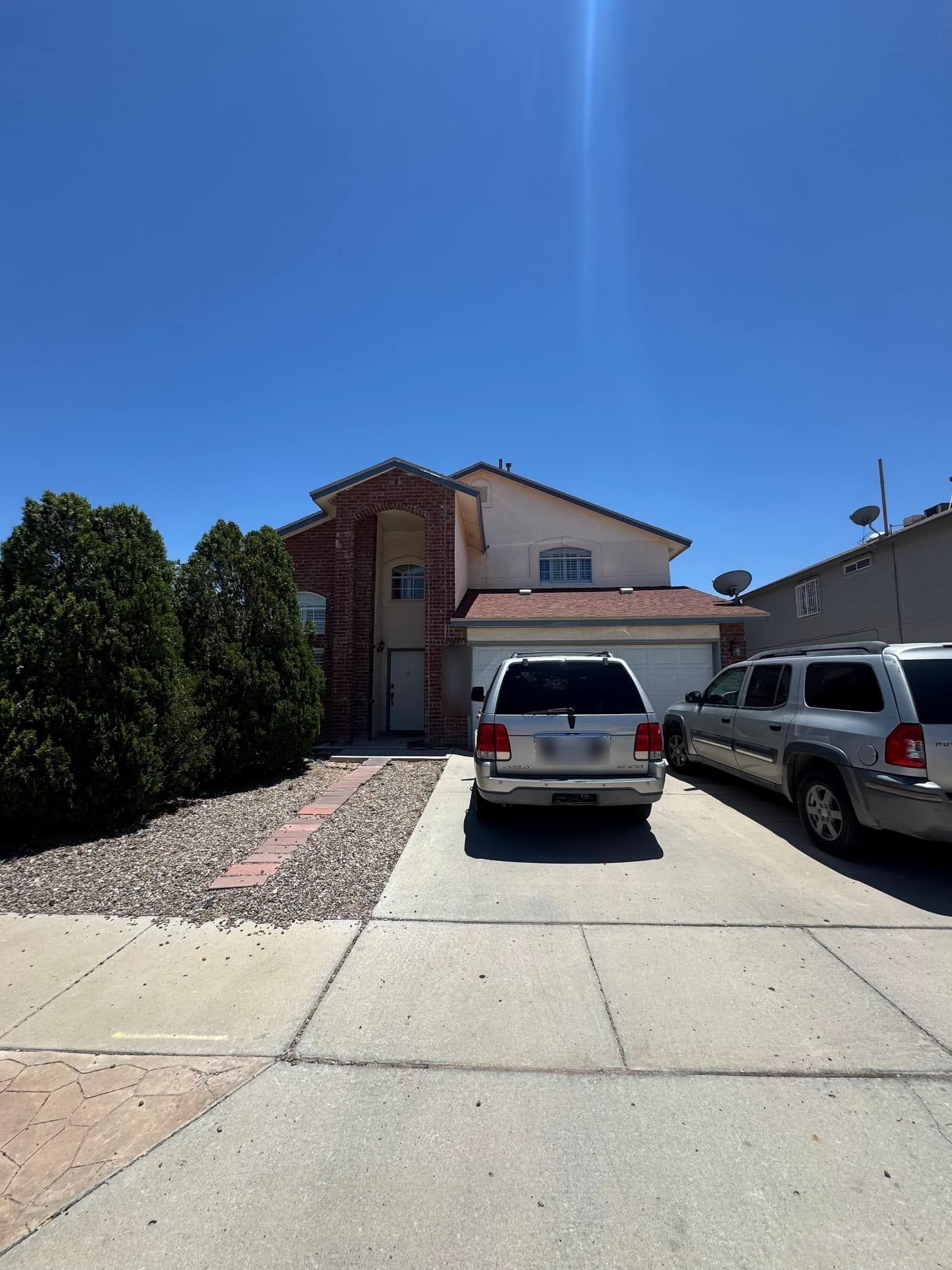 Two-storey stucco house in far east El Paso with a brick accent and a concrete driveway
