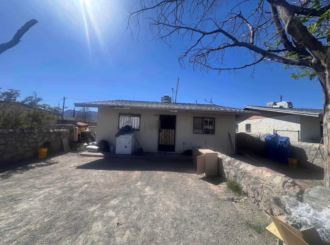 Single-storey flat-roof house in northeast El Paso with a gravel yard, seen from the driveway