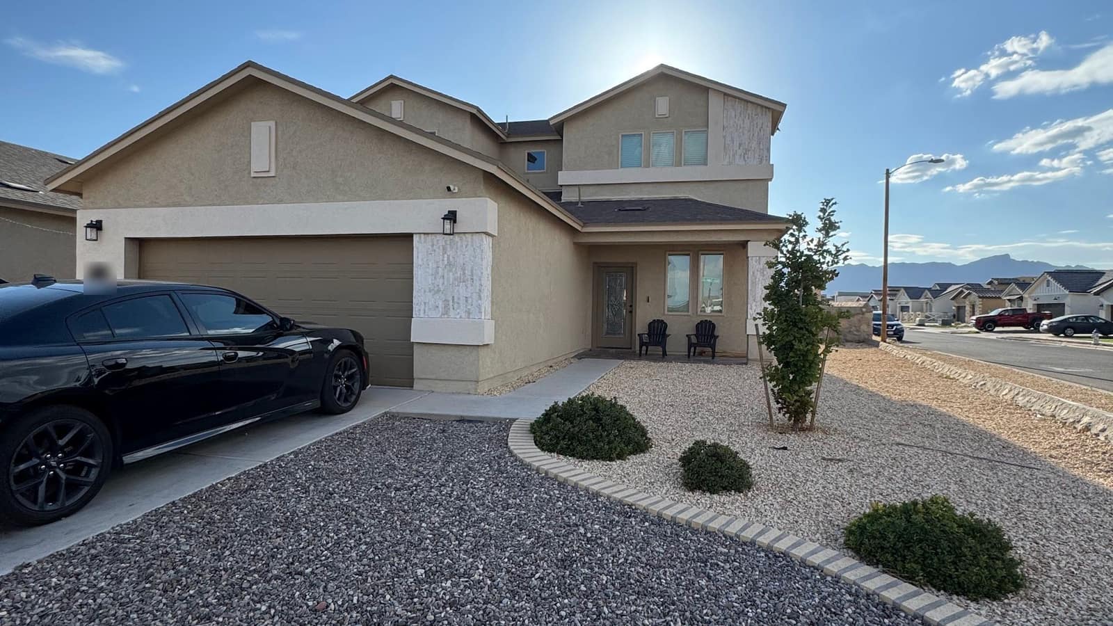 Two-storey stucco house in northeast El Paso with a two-car garage and gravel front yard